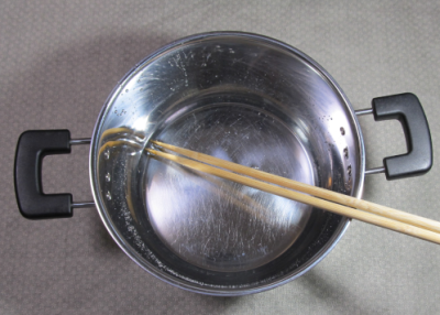 鍋に箸を入れる
